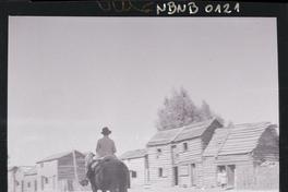 [Campesino a caballo por una calle rural]