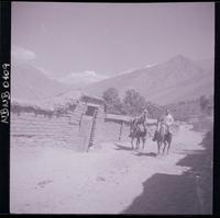 [Tres campesinos y un bebé a caballo por un paraje rural]
