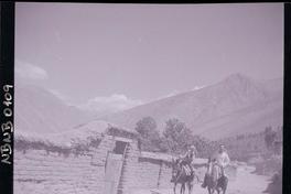 [Tres campesinos y un bebé a caballo por un paraje rural]