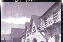 [Fachada de una casa y torre de piedra con reloj]