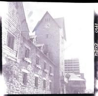 [Fachada de una casa y torre de piedra con reloj]