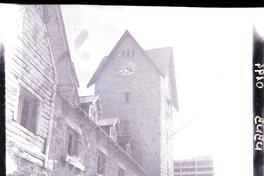 [Fachada de una casa y torre de piedra con reloj]