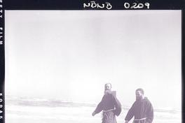 [Dos religiosos de la Orden Capuchinos, pasean por la orilla de la playa]