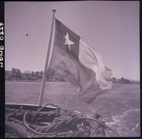 [Detalle en el que en un sencillo mástil de una lancha flamea una bandera chilena]