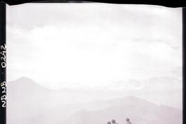 [Tres hombres sentados en un mirador de piedra mirando el valle]