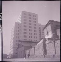 [Dos personas caminando por una calle frente la Moneda, vereda sur]