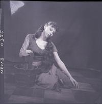 [Bailarina de ballet caracterizada para una obra, posando sentada en el piso]