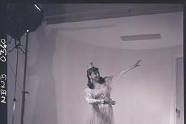 [Bailarina de ballet, caracterizada para una obra, posando de pié en una posición de movimiento]