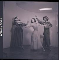 [Dos bailarinas y un bailarín de ballet caracterizados para una obra, posan en una posición de movimiento]