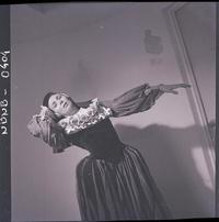 [Bailarina de ballet, caracterizada para una obra, posando en una posición de movimiento]