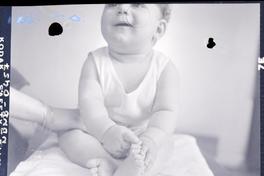 [Bebé sonriendo sentado sobre una mesita]