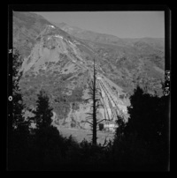[Desarrollo de las tuberías desde la chimenea de equilibrio hasta la central y el entorno con gran vegetación en que predominan los cipreses]