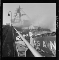 [Grúa de embarque junto a un barco en el puerto]