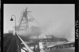 [Grúa de embarque junto a un barco en el puerto]