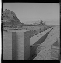 [Faja transportadora de minerales y contenedores a tajo abierto, en el puerto de embarque]