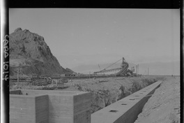 [Faja transportadora de minerales y contenedores a tajo abierto, en el puerto de embarque]