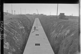 [Faja transportadora de minerales y contenedores a tajo abierto, en el puerto de embarque]