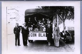 [Grupo de españoles, un grupo parado y otros en la parte de atrás de un camión]