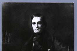 [Retrato de un hombre de medio cuerpo sentado junto a una mesa, con una pluma en la mano]