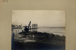 [Muelle de faena, se divisa una grua, rieles de ferrocarriles y algunas personas]