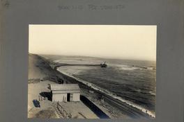 [Vista de una línea férrea que pasa la orilla del mar, hacia el terminal ferroviario]