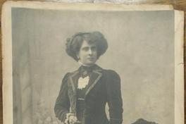 [Mujer joven vestida con un conjunto de terciopelo, vestido y chaqueta larga, blusa de cuello alto, luce joyas]