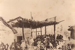 [Cueca: parejas bailando cueca acampada en una ramada, con campesinos]