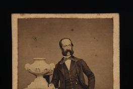 [Lucas Grez, retrato de cuerpo entero afirmado en un pilar]