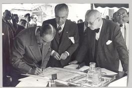 [Guillermo Feliú Cruz y dos personajes más, firmando un documento]