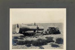 [Grupo de trabajadores, transportan una estructura hidraúlica en un carro de carga del ferrocarril]