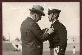 [Ministro de Defensa Don Emilio Bello Codesio, colocando el gran premio al Cadete Onofre Torres Riesle, en la premiación de la Escuela Naval]