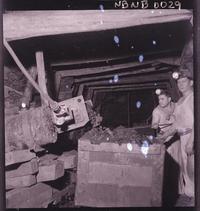 [Mineros y carro de acarreo en galería subterránea de la mina]