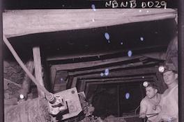 [Mineros y carro de acarreo en galería subterránea de la mina]