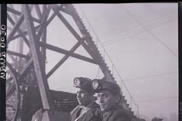[Mineros junto a la torre de los pozos mineros]