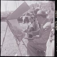 [Niño observa a Arturo Pacheco Altamirano, mientras pinta paisajes en la caleta de Angelmó]