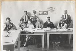 [Grupo de personas en mesa de votación]