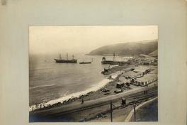 [Vista general del terminal marítimo, del muelle, se divisan vías férreas a orillas del mar, y un barco en el mar]
