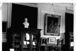 [Biblioteca Nacional. Sala José Toribio Medina, sala del Conservador, se divisan estanterías, un escritorio y cuadros]